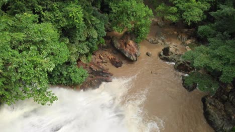 strong water flow down waterfall in dense lush green jungle rainforest