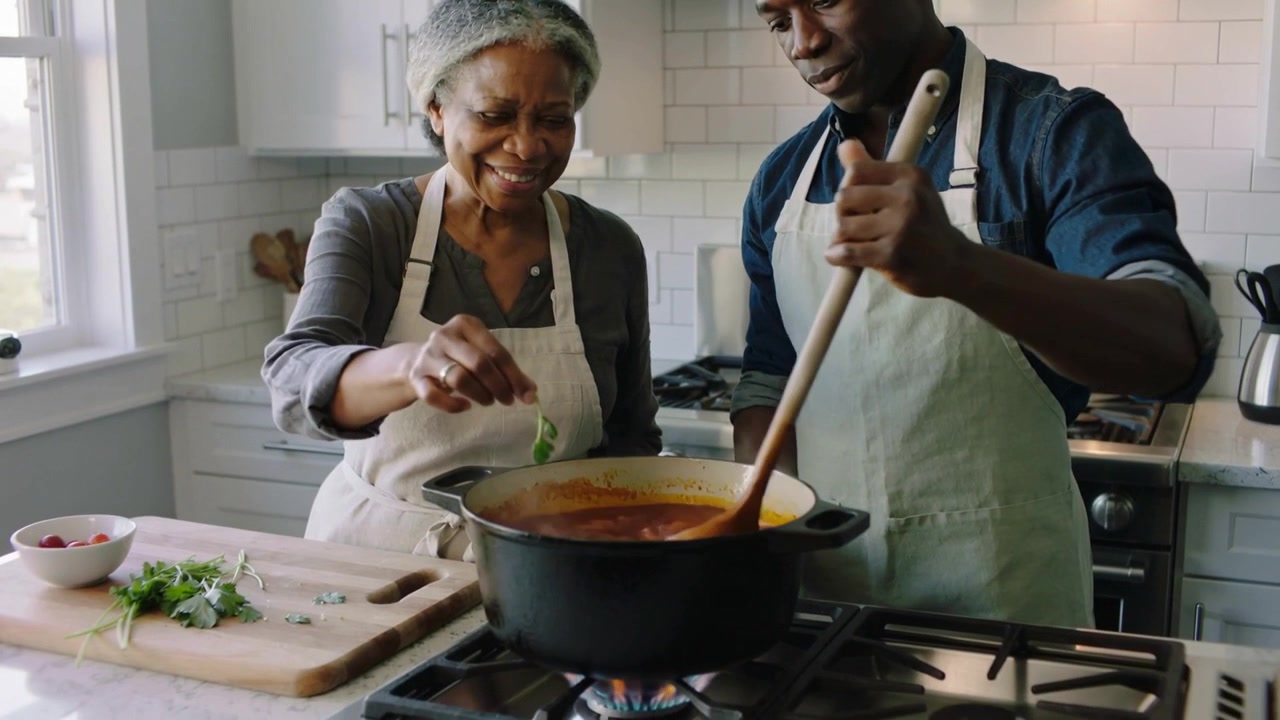 Picking wooden spoon, mother and son aproned stirring pot in home kitchen, adding herbs to soup