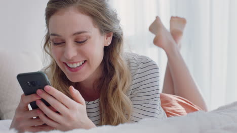 Hermosa-Mujer-Teniendo-Video-Chat-Usando-Un-Teléfono-Inteligente-Charlando-Con-Un-Amigo-Disfrutando-De-Una-Conversación-Acostada-En-La-Cama-Relajándose-En-Casa