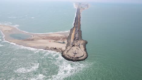 high-altitude aerial drone shot of dhanushkodi, showcasing the last road of india against the oceanic backdrop.