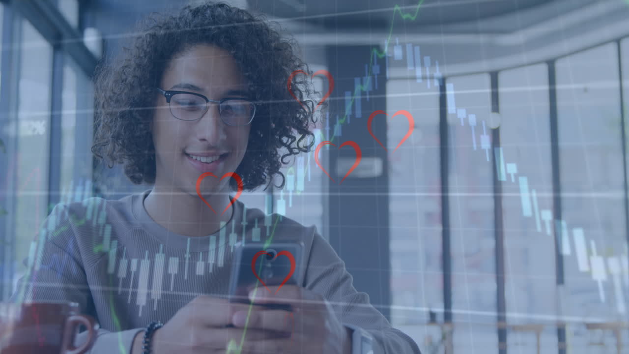 animación del procesamiento de datos financieros y corazones sobre un hombre biracial usando un teléfono inteligente