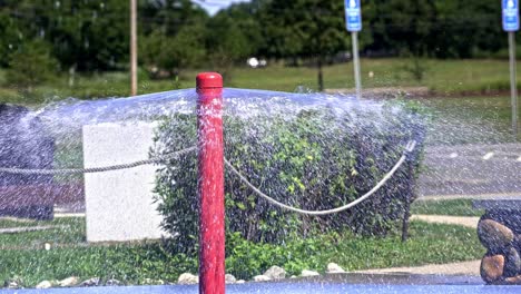 water sprays joyfully from a vibrant red fountain