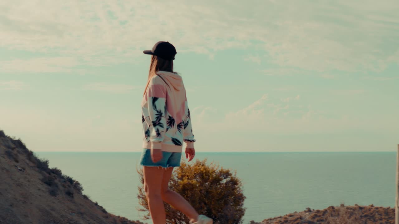 Donna che fa escursionismo sulla cresta di una montagna con il Mar Mediterraneo sullo sfondo