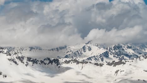 vuelo aéreo a través de nubes montañosas sobre hermosos picos nevados de montañas y glaciares.