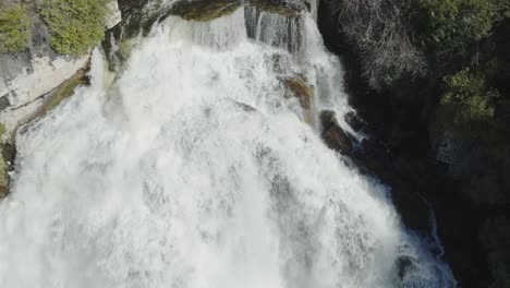 Majestic-waterfall-in-Owen-Sound,-Canada-with-powerful-rushing-water-and-lush-greenery-surrounding