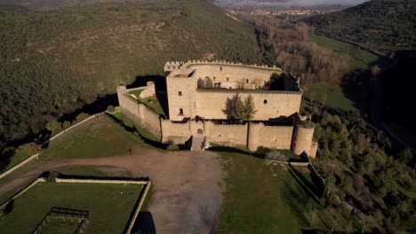 aerial dolly out focusing on medieval stone castle in pedraza spanish village at sunrise