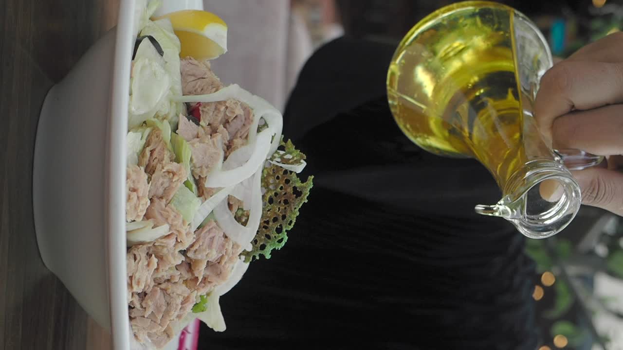 Tuna salad being drizzled with olive oil