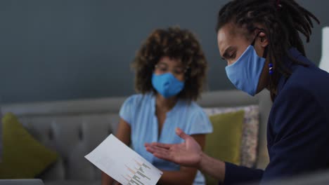 diverse business colleagues wearing face masks in discussion at a casual meeting