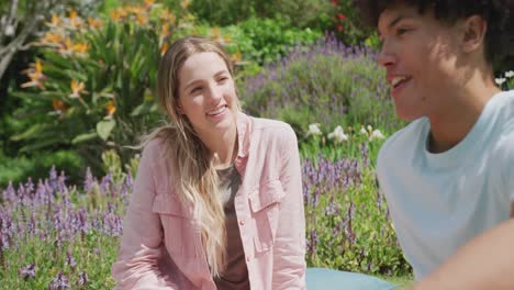 happy diverse couple having picnic in garden on sunny day