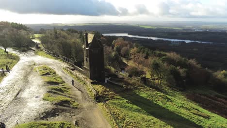 historic creepy fairy tale rivington pigeon tower aerial low orbit left overlooking english winter hill farming countryside