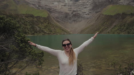 woman enjoying the scenery near a lake surrounded by mountains