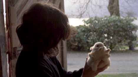 Woman-holding-and-petting-white-rabbit-in-farm_slomo