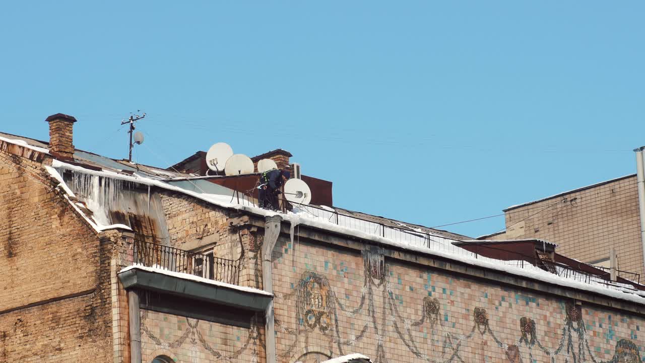 Lavoratore su un tetto innevato in inverno