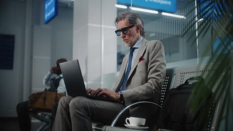 businessman working on laptop in airport
