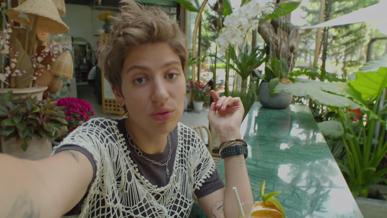 Young Woman Talking on Camera in Outdoor Summer Cafe