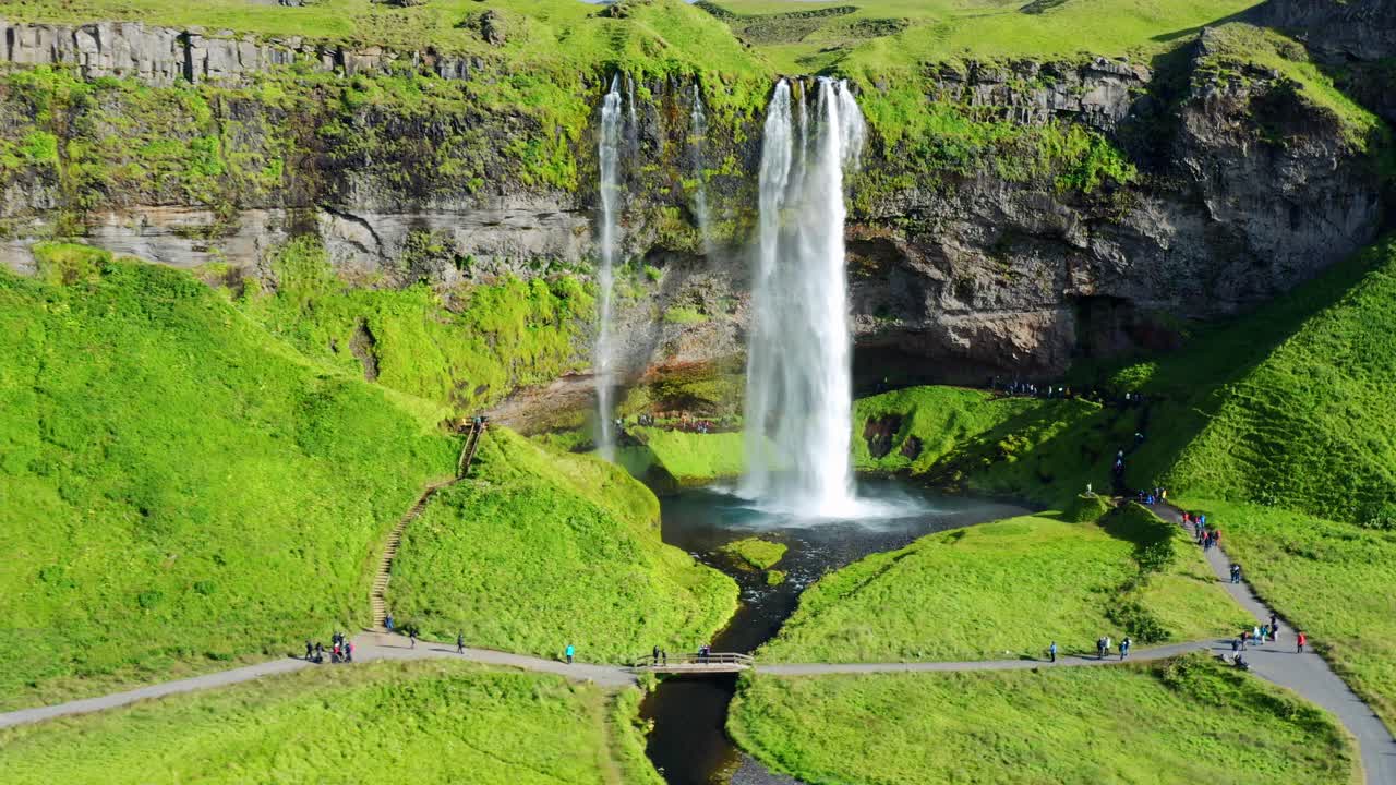 la gente visita la cascada seljalandsfoss con naturaleza verde en verano en el sur de islandia
