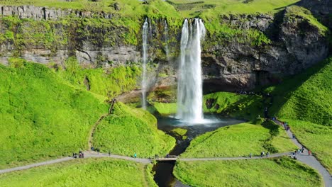 Menschen-Besuchen-Im-Sommer-In-Südisland-Den-Wasserfall-Seljalandsfoss-Mit-Grüner-Natur