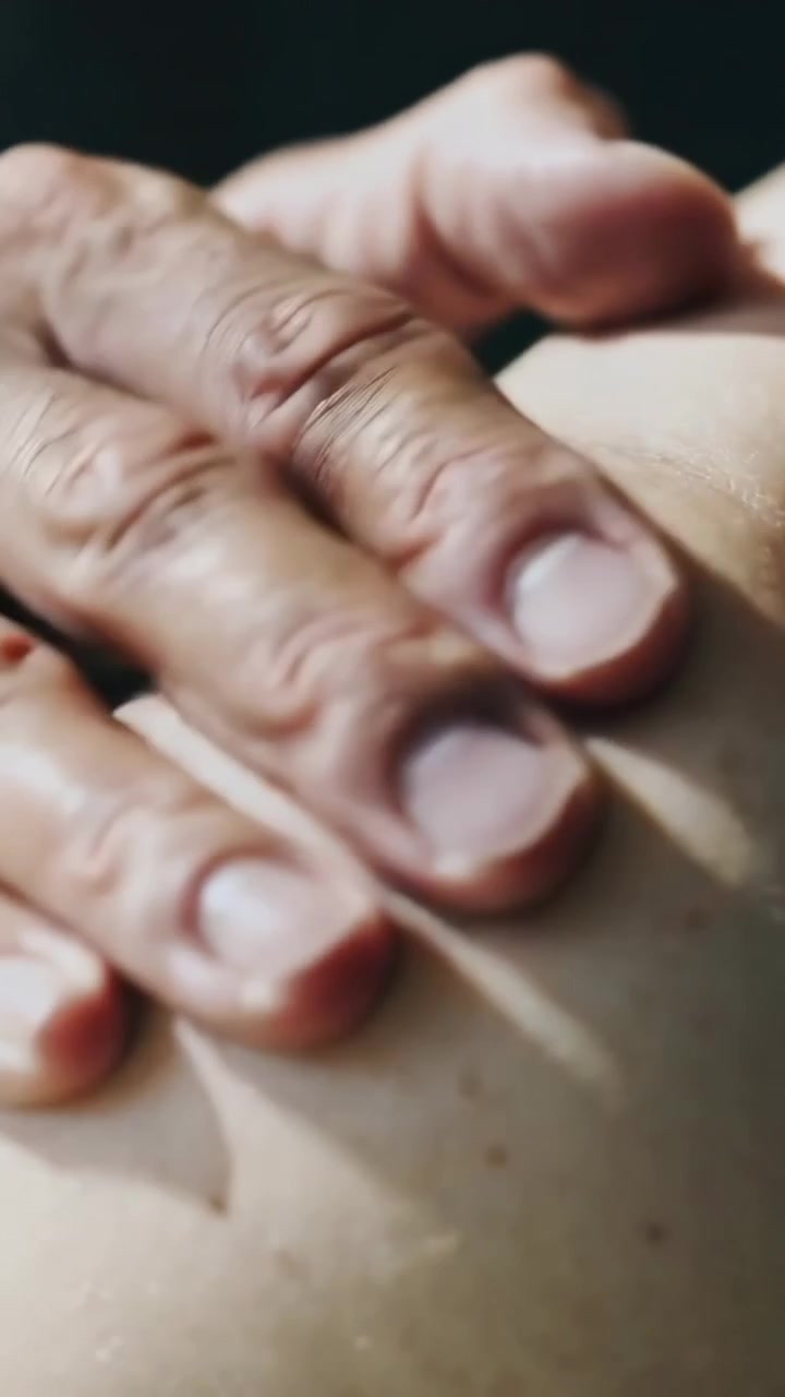 Vertical video: Placing adult hand pressing sliding kneading bare skin in dim room easing tension