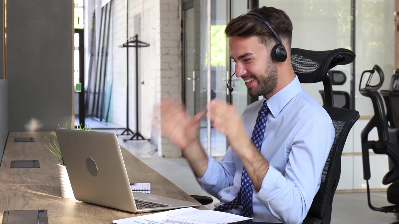 Uomo d'affari sorridente che parla in videochiamata con l'auricolare