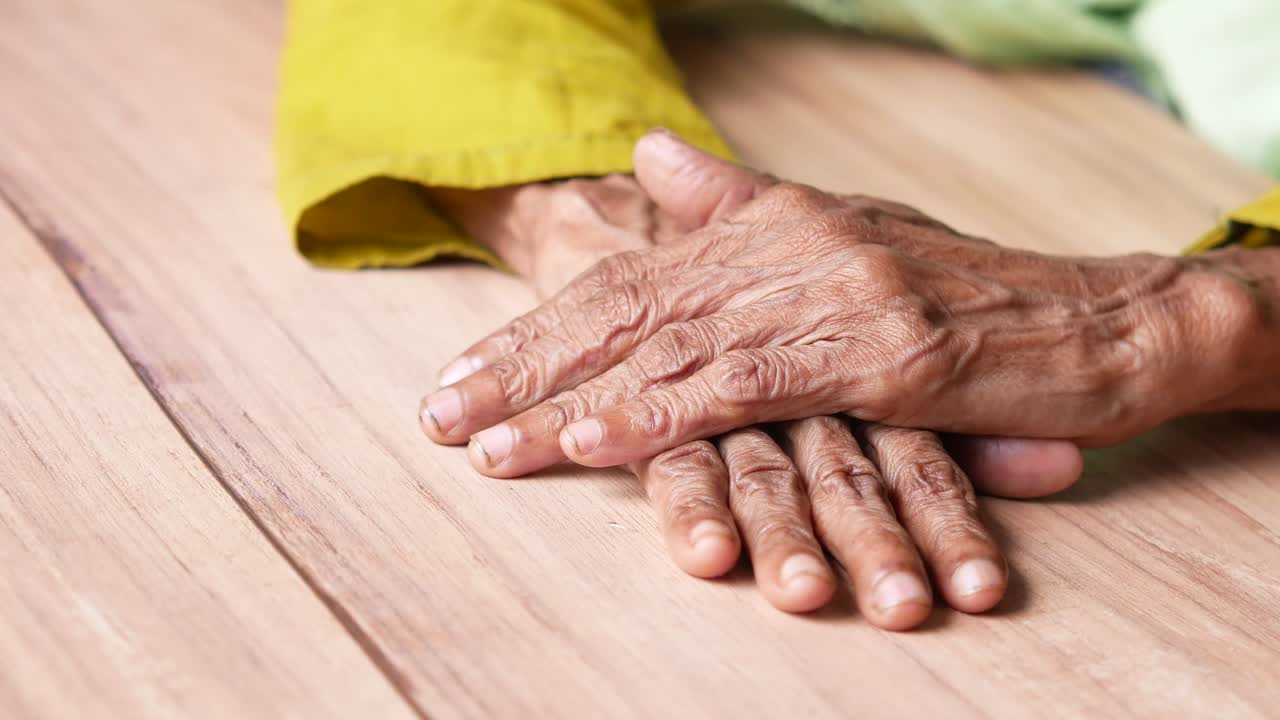 나무 테이블 에 손 을 고 있는 노인 들