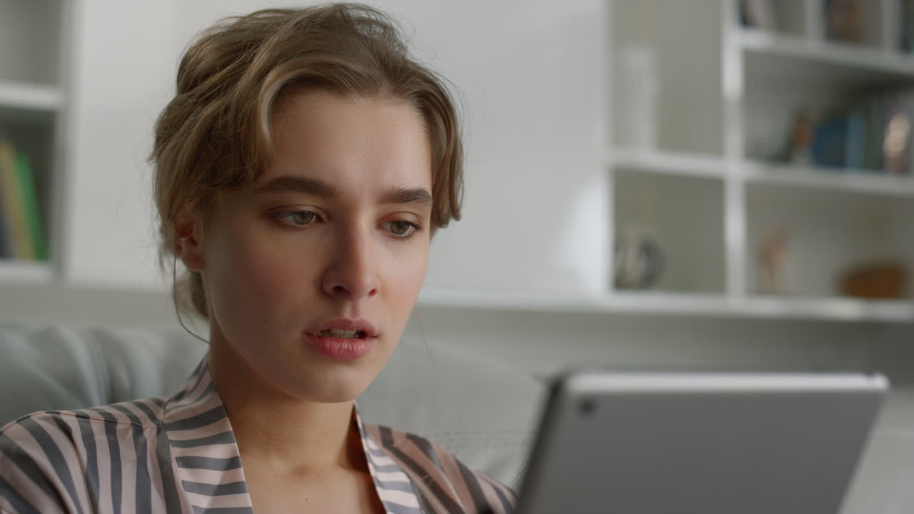 una mujer de negocios leyendo noticias tristes sostiene una tableta de primer plano. una chica molesta mira la pantalla del pad.