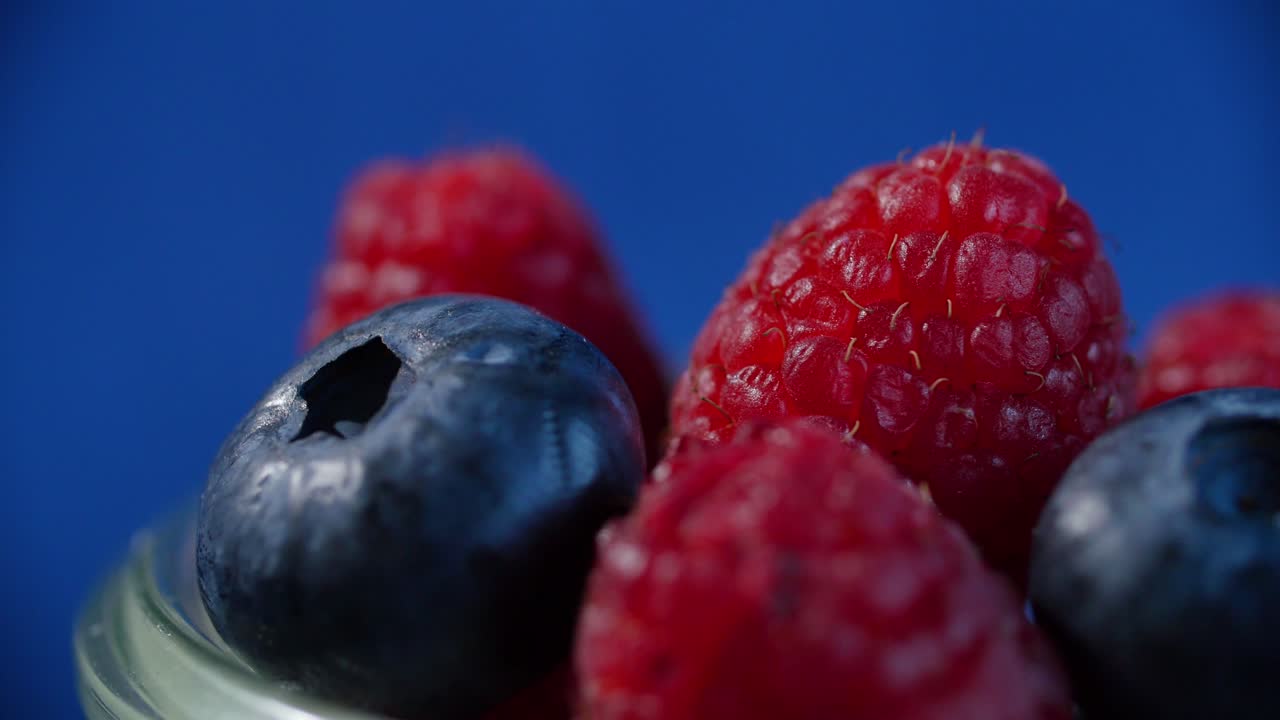 frambuesas y arándanos en un frasco de vidrio