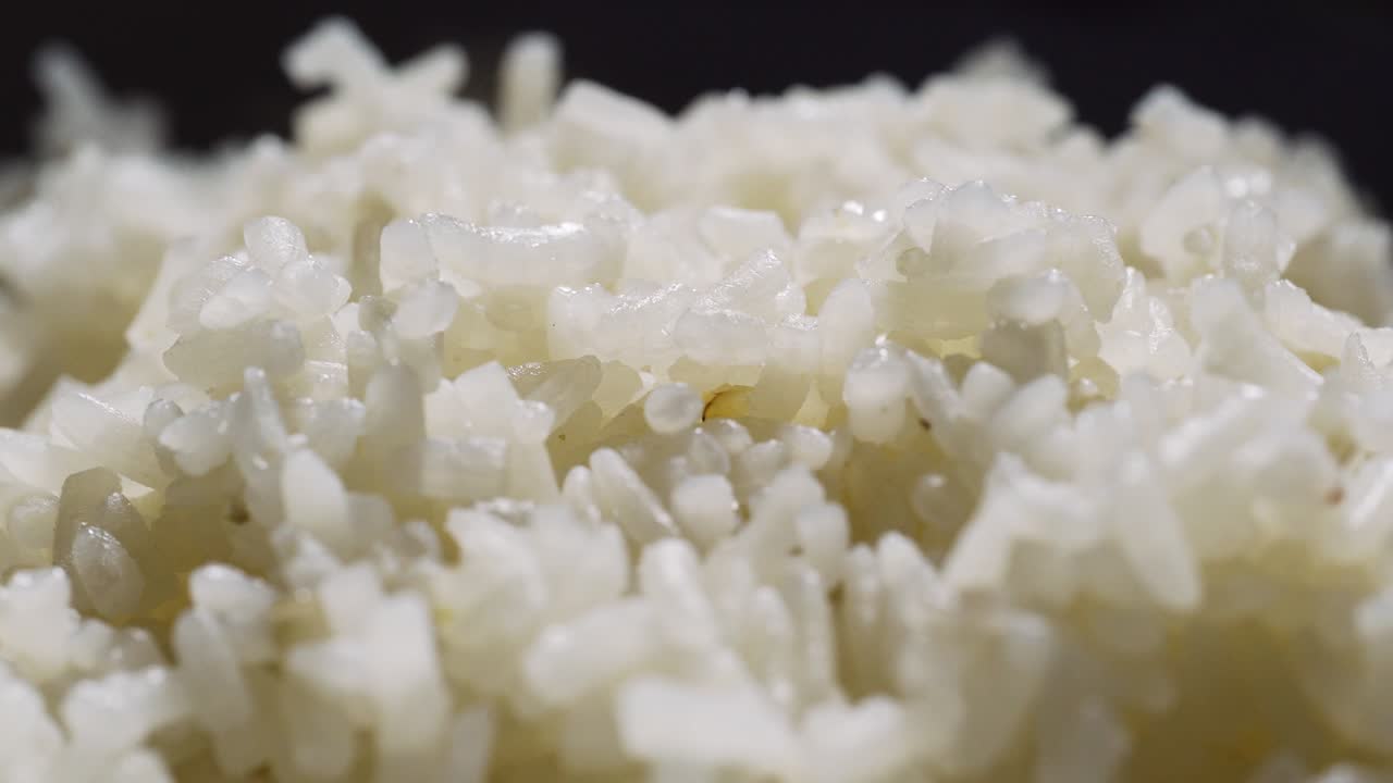 arroz cocido girando en una mesa giratoria. macro shot. arroz tailandés. comida asiática.