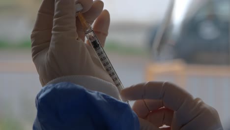 close-up of measuring out a dose of an injectable vaccine