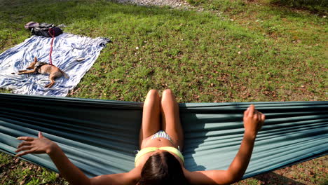 mixed race beautiful long black hair woman relaxing in hammock while camping in wild nature