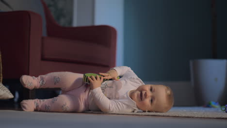 niña acostada y jugando en el suelo