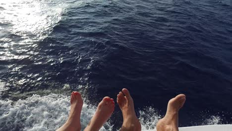 pies en la cubierta de un velero o yate que navega en el mar