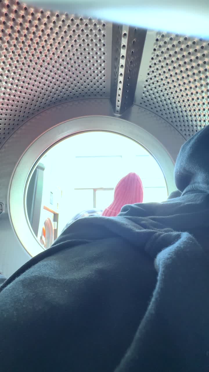 Person Loading Clothes into a Washing Machine