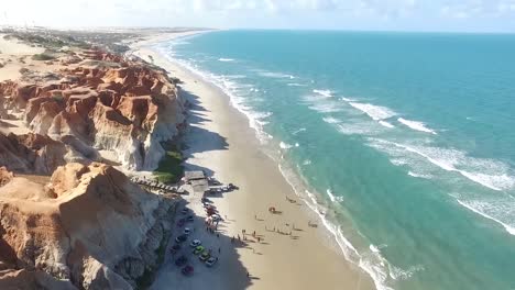 imágenes aéreas de drones del paisaje rocoso en la famosa playa soleada de américa, con olas serenas del mar llegando suavemente a la costa, destacando el contraste entre el terreno escarpado y el océano