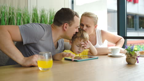 Dreiköpfige-Familie-Mit-Block-Im-Café