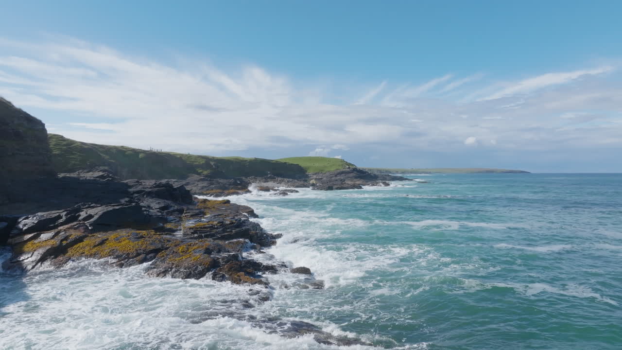 Aerial footage of rugged coastal cliffs near Eoropie on the Isle of Lewis, where Atlantic waves crash against dark gneiss rock beneath bright skies. Wild, remote, and cinematic Hebridean coastline