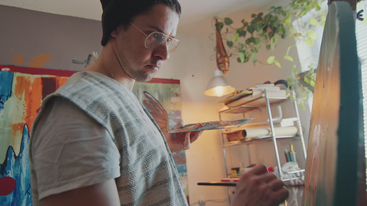 artista inspirado pintando en lienzo en un acogedor estudio creativo