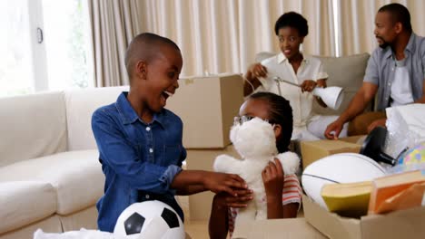 Parents-and-kids-unboxing-cardboard-boxes-in-living-room