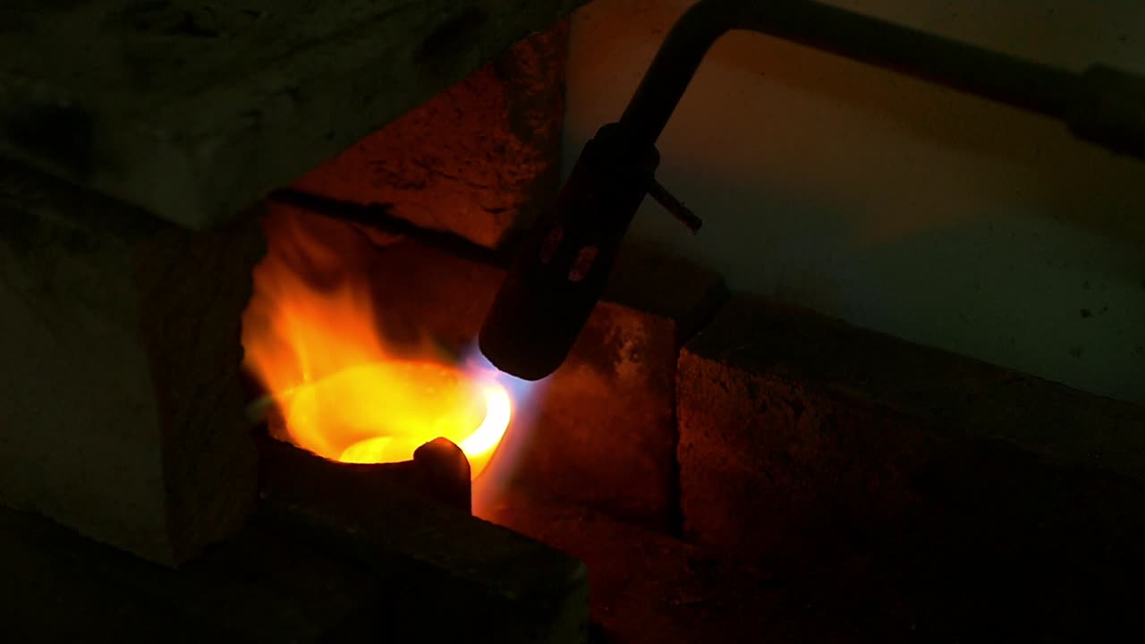 도가니 안에서 귀금속을 토치로 가열하여 고온에서 녹이는 모습