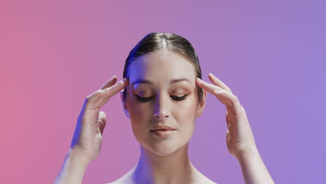 caucasian woman with brown hair and make up touching her temples, copy space, slow motion