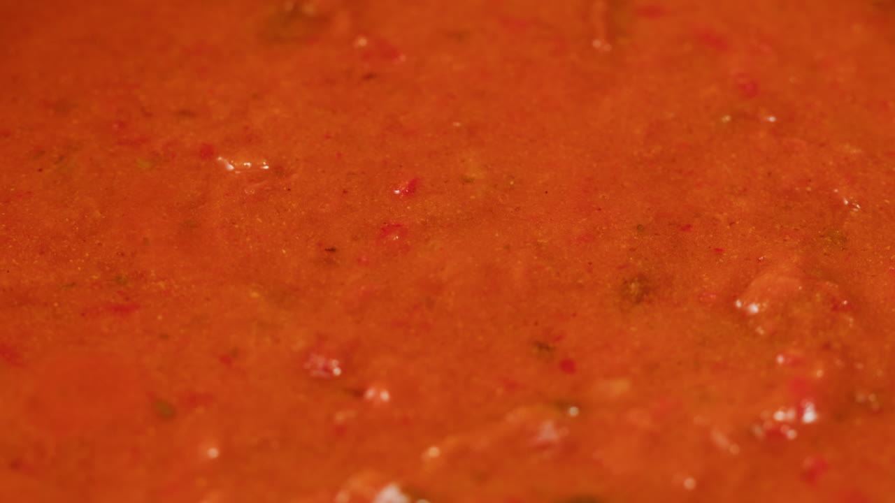 Chicken in tomato sauce is boiling on a frying pan with spices. Cooking tomato sauce curry with chicken fillet. Traditional Italian Mexican Asian dish. High quality studio shot for cafe, restaurant close up.