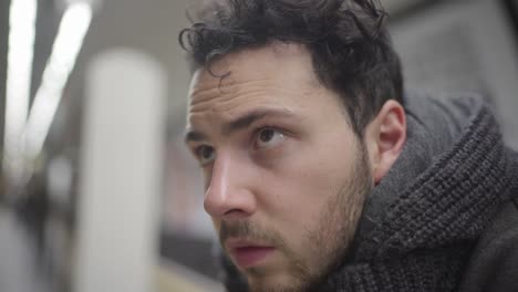 an unhappy and depressed guy on metro looks like worried and thoughtful about his future. a sad face expression on him