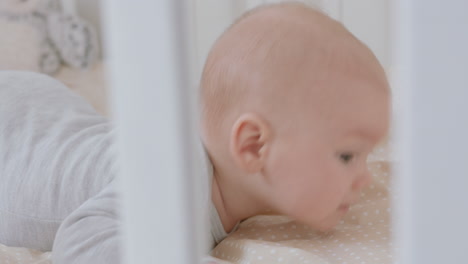 cute newborn baby in crib looking curious playful infant lying in nursery cot