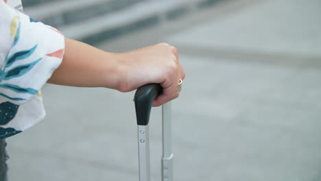 Mano-Femenina-Sosteniendo-El-Asa-De-La-Maleta.-Primer-Turista-Mujer-Caminando-Con-Equipaje