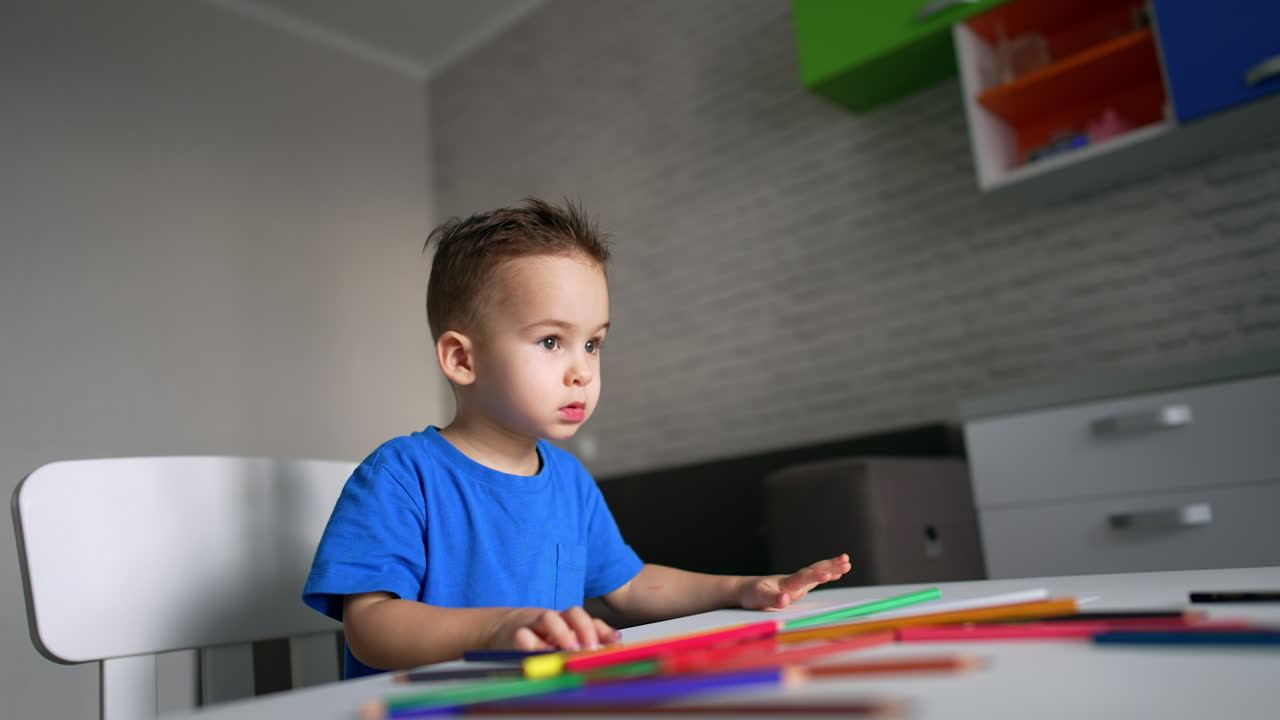 Concepto de niño pequeño y lindo dibujando. Lindo niño juguetón pintando con lápices.