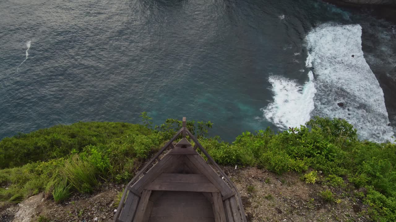 persona adulta en el acantilado de paluang de nusa penida sentada en la plataforma de punto de vista de proa del barco y lugar de fotos con vistas al paisaje marino de kelingking
