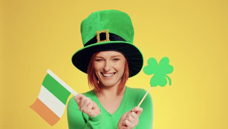 Woman-with-leprechaun's-hat,-Irish-flags-and-clover-shaped-banner