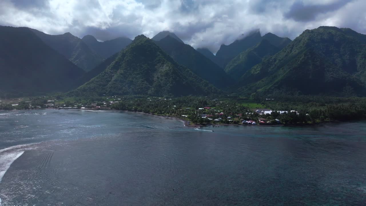 Teahupoo Tahiti new Pedestrian Bridge aerial drone view French Polynesia bay coastline boats blue sky clouds WSL Surfing summer Olympic venue town village mountain peaks surfer wave reef forward up