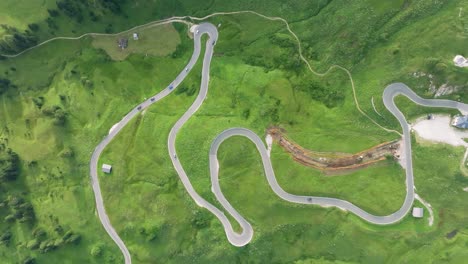 vista aérea de vehículos que conducen por las sinuosas carreteras de passo gardena en las montañas dolomitas, trentino, tirol del sur, italia