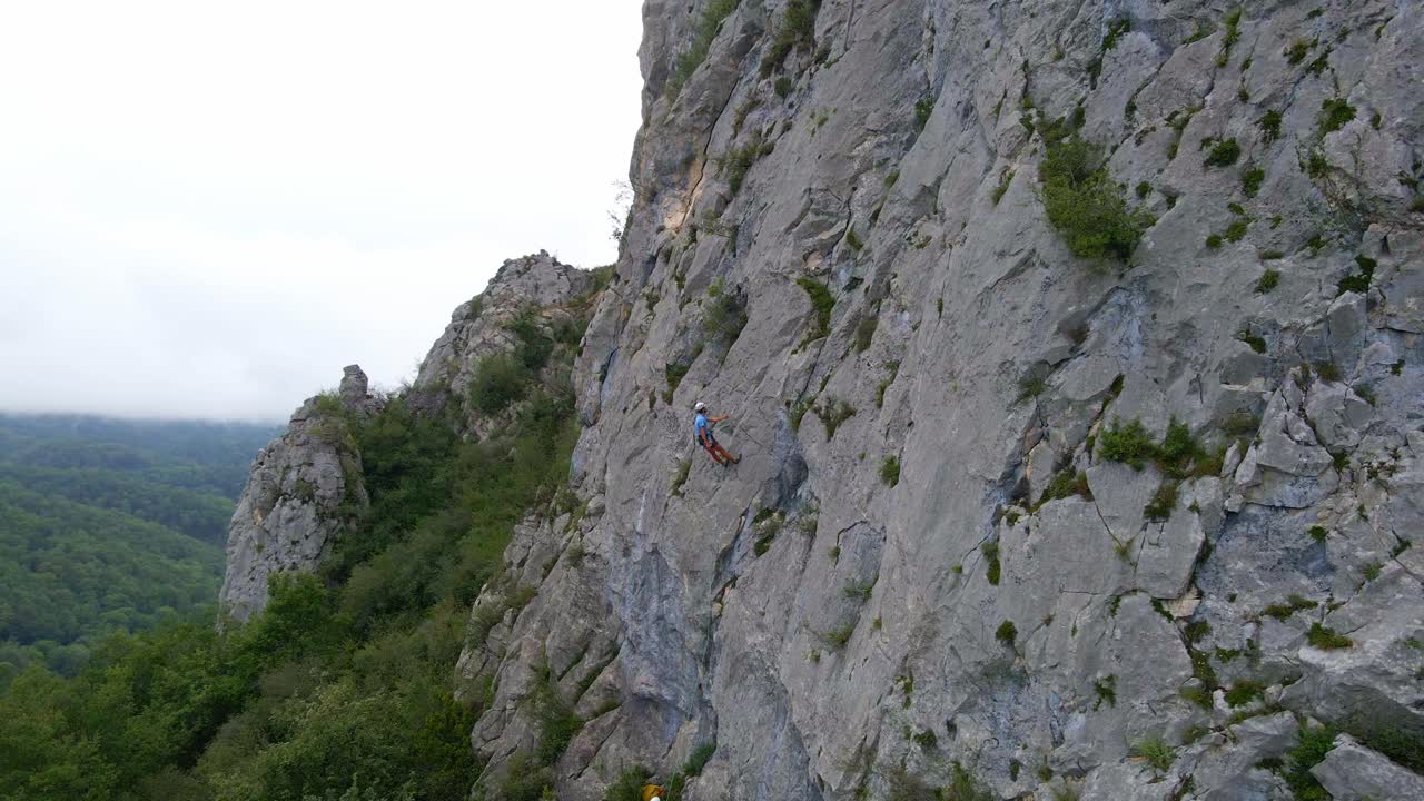 Circular drone footage of a man stopped while lead climbing in the Pyrenees moutains at Tarascon sur Ari&egrave;ge