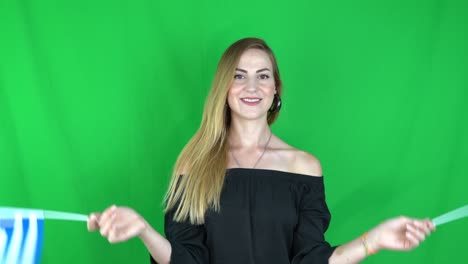 young blonde woman waving greece flag with turkey flag flag in front of green background